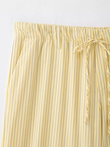Détail du pantalon rayé jaune avec taille élastique, cordon de serrage et passants de ceinture
