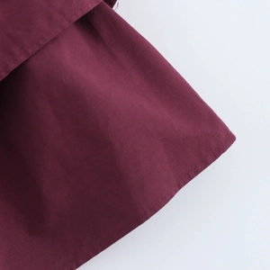 Close-up of high-quality sewing stitches on wine red dress hem with smooth fabric