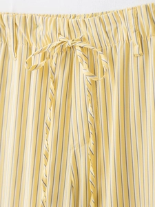 Détail du pantalon à rayures jaunes et blanches avec taille élastique et cordon de serrage