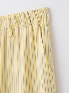 Détail de la taille élastique et des poches sur ce pantalon plissé à rayures jaunes et blanches