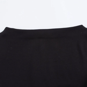 Close-up of black boat neck knit dress showing clean seam edges and fine pleated fabric