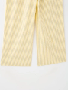 Détail du pantalon à rayures verticales jaunes et blanches avec coutures de qualité