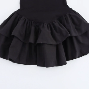 Detailed close-up of the black layered ruffled hem on this chic pleated dress