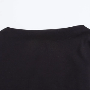 Detail of a black knitted dress showing the clean neckline and high-quality fabric texture