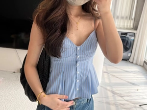 Detail shot of blue and brown striped camisole top with white buttons and ruffled hemline