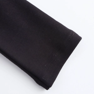 Close-up detail of double-needle stitching on black knit dress cuffs for a clean finish
