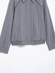Detailansicht der grauen Nadelstreifenjacke mit Rippbündchen und schrägen Taschen