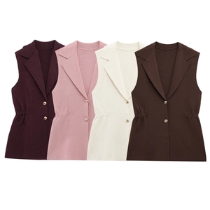 Détail des boutons dorés et des plis à la taille sur les gilets en maille sans manches