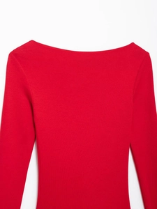Detail view of red boat neck pleated dress showing knit texture and collar stitching