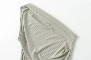 Detail of sage green ribbed knit fabric featuring asymmetrical neckline and fine texture