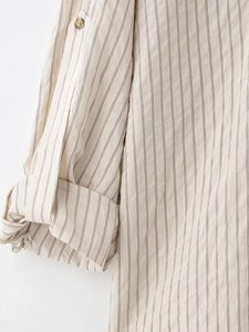 Detailed close-up of striped shirt sleeve with adjustable button tab and linen texture
