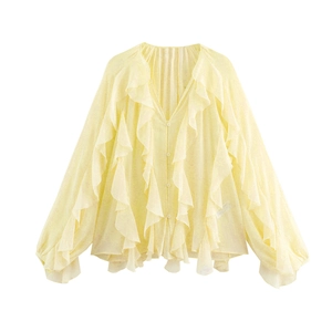 Detail of layered ruffles and buttons on light yellow chiffon v-neck long sleeve shirt