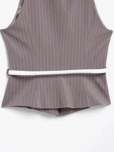 Dettaglio del gilet grigio gessato con sottile cintura bianca e trama fine del tessuto