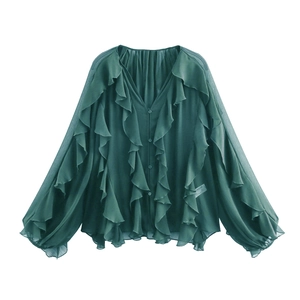 Detail of dark green chiffon blouse showing layered ruffles and textured fabric