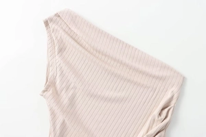 Close-up of pink ribbed knit fabric showing asymmetrical shoulder strap and fine texture
