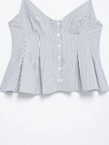 Detail of striped bustier top featuring white buttons and a flared peplum hemline