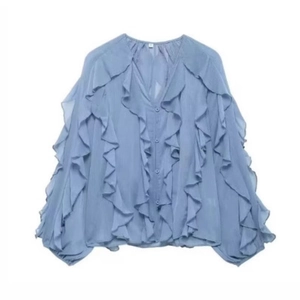 Detail of light blue chiffon blouse showing ruffled layers and elegant V-neckline texture