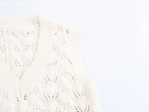 Détail du motif ajouré complexe et de l'encolure en V côtelée de ce gilet en maille de coton