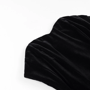Gros plan sur la robe en velours noir montrant le drapé raffiné et la texture douce