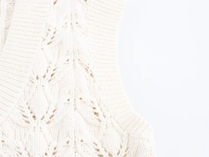 Détails de maille torsadée sur un gilet en coton blanc cassé avec textures en relief