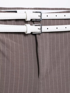 Dettaglio dei pantaloni grigi a righe a vita alta con doppie cinture bianche effetto coccodrillo