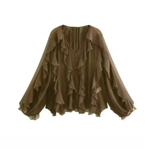 Detail of multi-layered ruffles and delicate buttons on olive green chiffon blouse