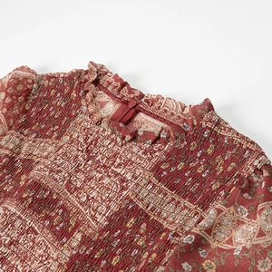 Detailed view of bohemian floral print dress with smocked bodice and ruffled neckline