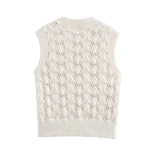 Détail du gilet en maille de coton blanc avec motifs ajourés et finitions côtelées