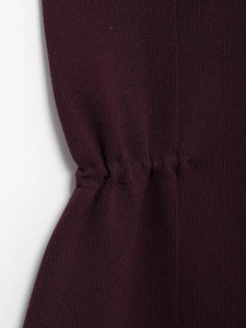 Détail du haut en maille violette montrant la taille plissée et la texture du tissu