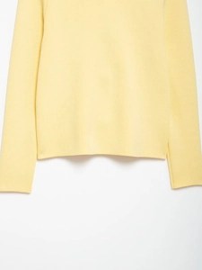 Close-up of ribbed knit texture and hem on light yellow long-sleeved cardigan