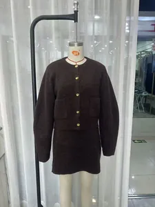 Close-up of dark brown knit cardigan with gold buttons and matching mini skirt