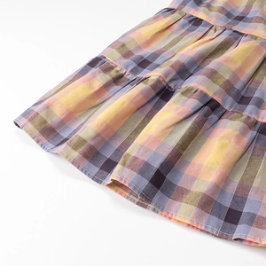 Detailed close-up of tiered plaid fabric featuring colorful layered stitching and cotton texture
