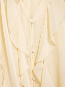 Detail of ruffle V-neck and buttons on cream chiffon blouse for a feminine style