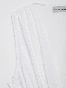 Detailed macro view of white textured pleated fabric with neck collar stitching