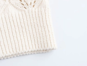 Détail du gilet en coton avec ourlet en maille côtelée et motif à texture ajourée