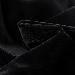Gros plan sur la texture velours noir haut de gamme avec reflets et beau drapé