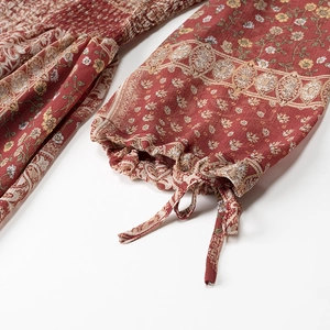 Detail of floral bohemian dress with smocked chest and ruffled cuffs with drawstrings