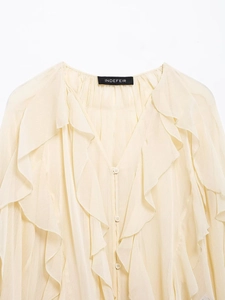 Detail of V-neck ruffled chiffon blouse in cream color with elegant layered textures
