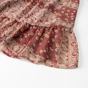 Macro detail of bohemian dress hem featuring paisley floral print and ruffle edges
