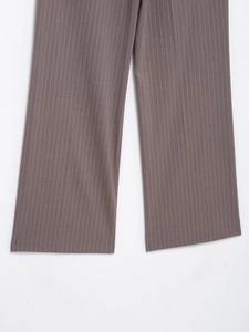 Dettaglio dei pantaloni eleganti taupe con sottili righe bianche e orlo dritto