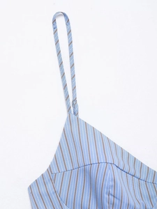 Detail of light blue pinstripe top featuring slim shoulder straps and clean stitching