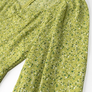 Detail of floral green dress featuring puff sleeves and back zipper for spring