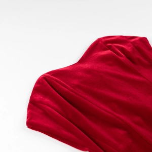 Détail de la robe en velours rouge avec plis drapés élégants et texture douce