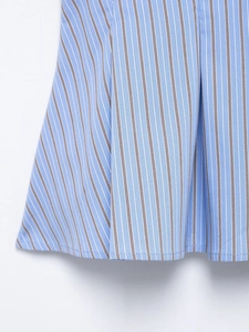 Detailed close-up of blue and white striped poplin fabric with pleated ruffle texture