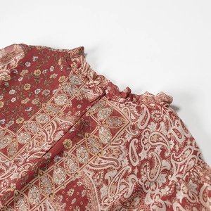Detail of ruffle stand collar and paisley floral print on vintage red dress fabric
