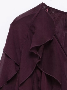 Detail of deep purple chiffon blouse featuring layered ruffles and fine fabric texture