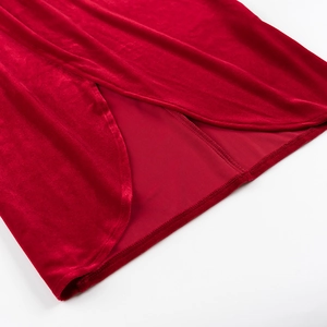 Gros plan détaillé de l'ourlet de la robe en velours rouge montrant les coutures précises