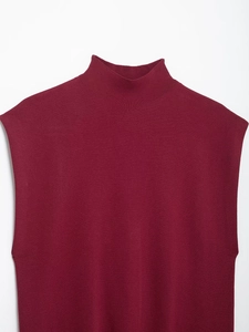 Close-up of wine red sleeveless knit top with mock neck and fine stitch texture