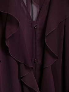 Detail of deep purple chiffon blouse featuring layered ruffles and tonal resin buttons