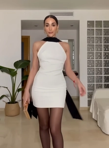 Détail de mini robe moulante blanche avec lien de cou noir contrastant et coupe ajustée